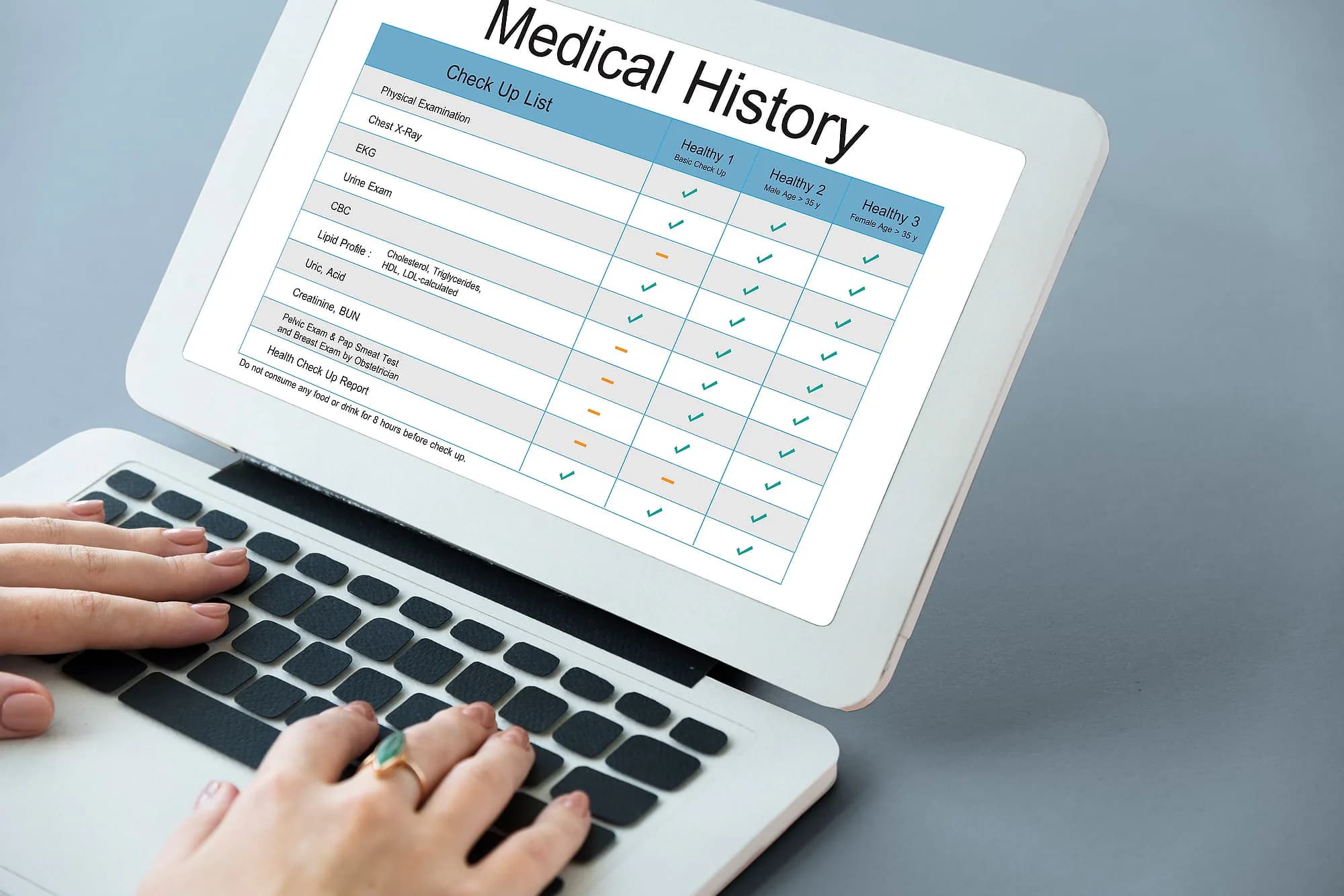 Clinician reviewing a patient's medical history record on a laptop