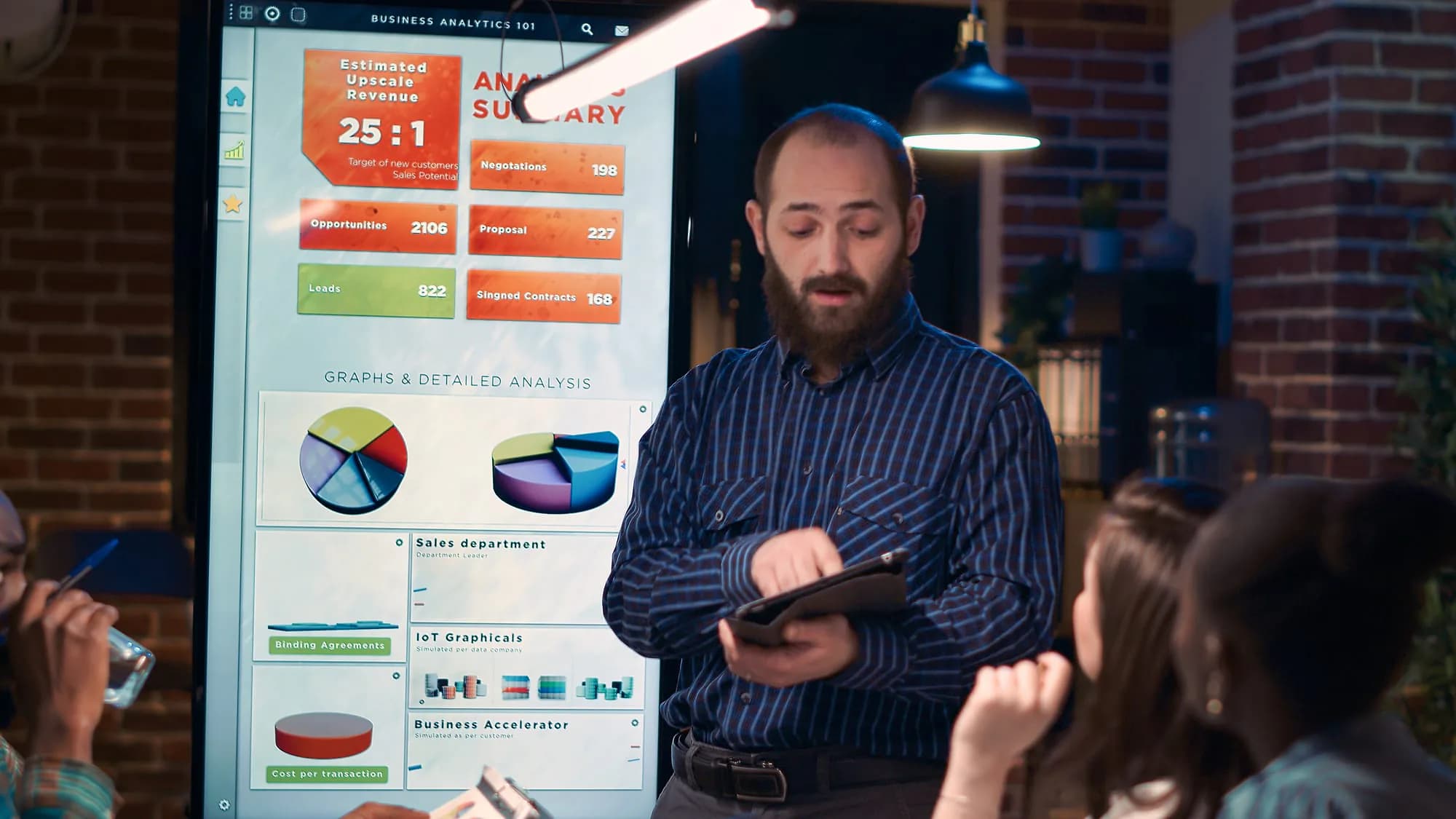 Analyst presenting performance figures to colleagues in a meeting room