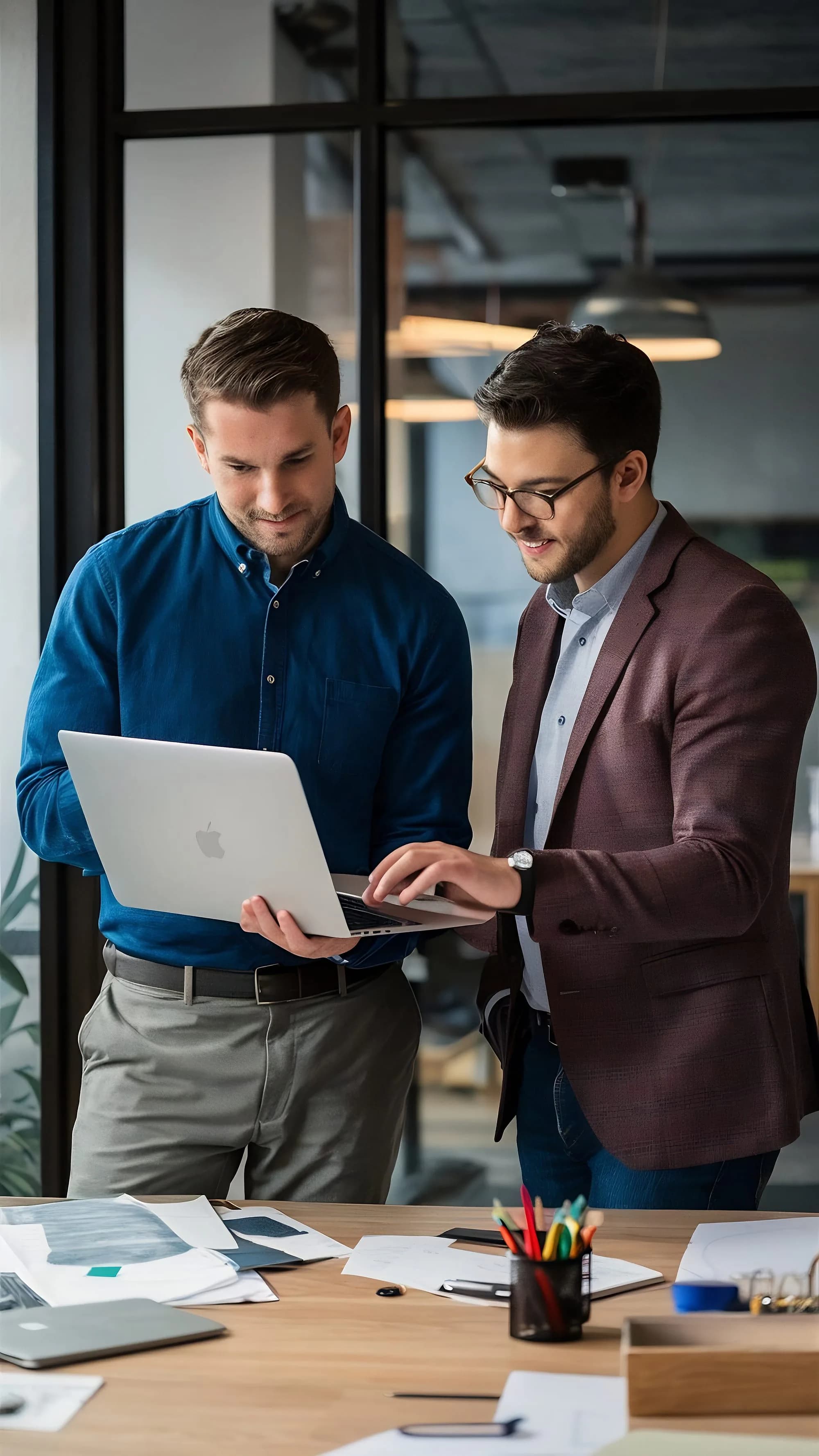 Two colleagues going through a question together on a laptop