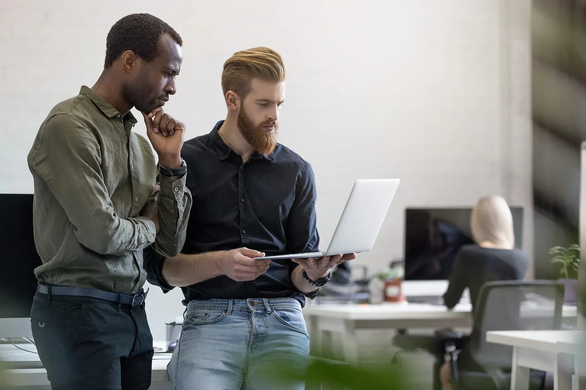 Two consultants assessing a legacy system together on a laptop